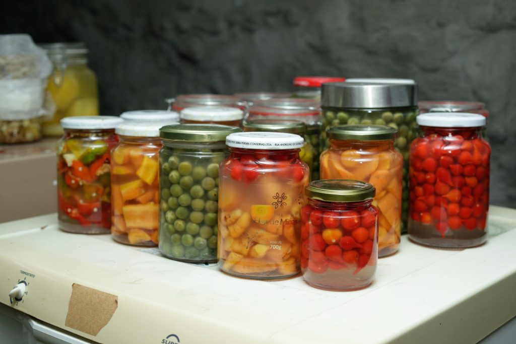 Bocaux de légumes et fruits lactofermentés alignés sur une étagère, aliments utiles pour reconstituer la flore intestinale