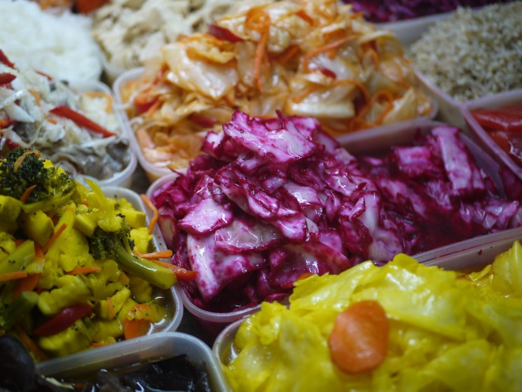 Assortiment de bocaux de légumes lacto-fermentés colorés, illustration d'une alimentation qui prend soin du microbiote intestinal