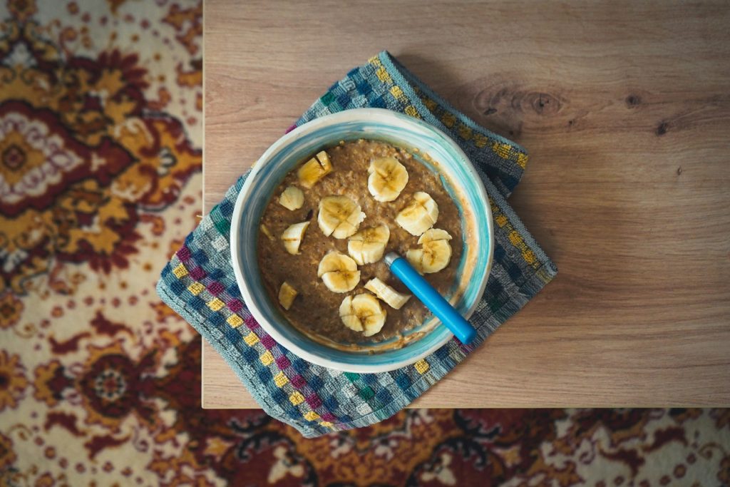 Bol de flocons d'avoine et de banane posé sur une table en bois, un petit-déjeuner doux pour le matin